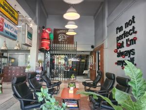 a waiting room with black chairs and a waiting room at The 8 Factory Hotel Phitsanulok in Phitsanulok