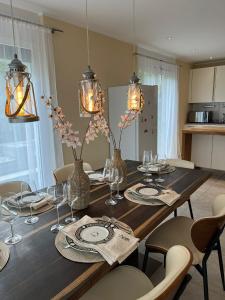 a dining room table with glasses and vases on it at Alpen Panorama view Luxury House with green Garden in Buchs