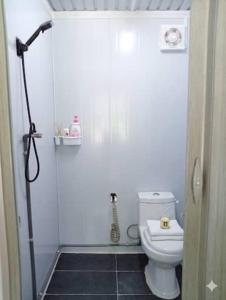 a bathroom with a shower and a white toilet at D'Cabin Roomstay in Sungkai +8 photos