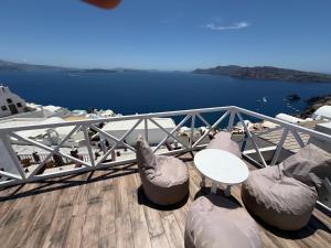 a balcony with a table and chairs and the water at Maryloujohn Villas Oia in Oia +217 photos