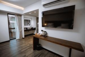 a living room with a large flat screen tv on a wall at The Wang Yaowarat Hotel in Bangkok