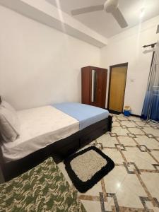 a bedroom with a bed and a rug on the floor at Liora Villa in Negombo