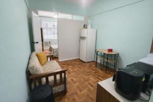 a living room with a couch and a refrigerator at Apto Central com Wi-Fi Rápido e Workspace in Niterói