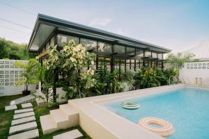 a house with a swimming pool in front of it at Marieli Suites near Panglao International Airport in Panglao Island