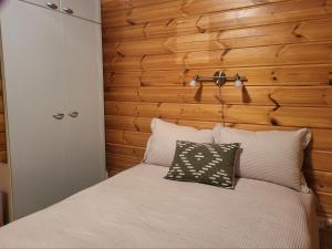 a bedroom with a bed with a wooden wall at Ilvesrinne - Cosy Fell-Side Cottage in Iso-Syöte in Syöte