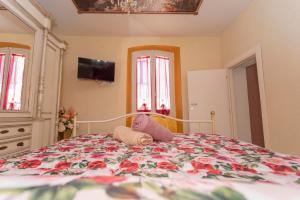 a bedroom with a bed with a floral bedspread at La Terrazza sul Lago in Capodimonte