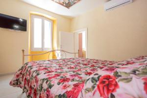 a bedroom with a bed with a flowered blanket at La Terrazza sul Lago in Capodimonte