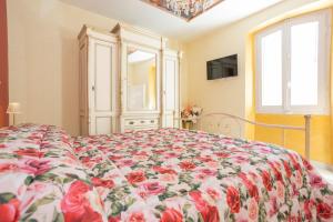 a bedroom with a bed with a floral bedspread at La Terrazza sul Lago in Capodimonte +26 photos