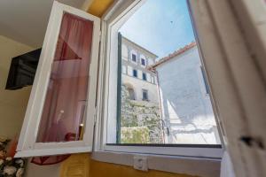 an open window with a view of a building at La Terrazza sul Lago in Capodimonte
