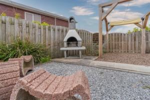a backyard with an outdoor oven in a yard at Bungalowpark Herkingen 1B in Herkingen