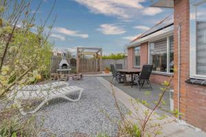 a patio with a bench and a table and chairs at Bungalowpark Herkingen 1B in Herkingen