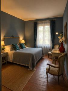 a bedroom with a bed and a chair and a window at Terracqua Retreat I Essence of Tuscany in Chiusi