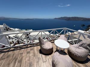 a balcony with a table and chairs and the water at Maryloujohn Villas Oia in Oia