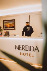 Ein Mann sitzt an einem Hotelrezeptionstresen in der Unterkunft Hotel Nereida in L'Estartit
