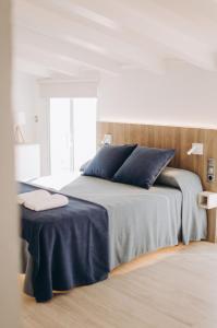 ein Schlafzimmer mit einem großen Bett und blauen Kissen in der Unterkunft Hotel Nereida in L'Estartit