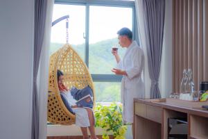 a man standing next to a woman sitting in a swing at Hotel Sampada Boutique in Pokhara