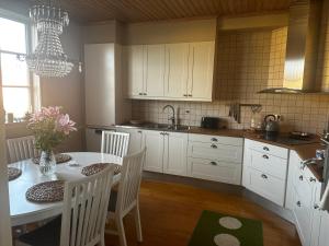 a kitchen with white cabinets and a table with chairs at Våning Margareta in Kalmar