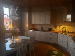 a kitchen with a table and white cabinets and a dining room at Våning Margareta in Kalmar +3 photos