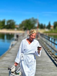 a woman walking on a pier looking at her cell phone at Våning Margareta in Kalmar