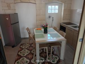 a small kitchen with a white table and chairs at casa di Chiarina con parcheggio gratuito nel cortile privato in Binetto