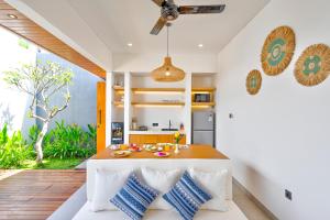 a kitchen and dining room with a table with blue and white pillows at Tapan Harmony Villa Ubud in Ubud