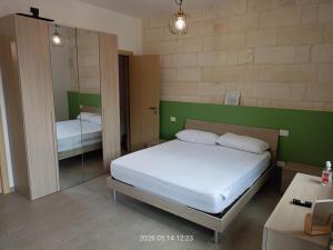 a small bedroom with a bed and a mirror at casa di Chiarina con parcheggio gratuito nel cortile privato in Binetto
