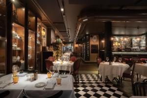 a restaurant with tables and chairs and a bar at Speronari Suites in Milan