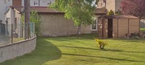 a yard with a fence and a small shed at Petit studio charmant in Lezoux
