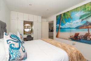 a bedroom with a bed with a large painting on the wall at Where Time Stops in Langebaan