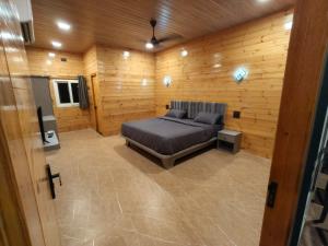 a bedroom with a bed in a room with wooden walls at Mount Bliss Resort in Mhasla