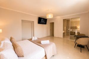a bedroom with a white bed with a sign on the wall at Fenisien Boutique Rooms in Contursi