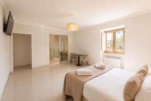 a white bedroom with a bed and a table at Fenisien Boutique Rooms in Contursi