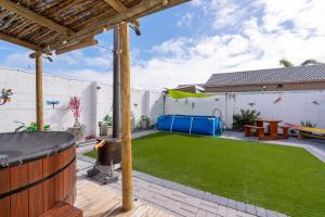a backyard with a fake lawn and a grill at Where Time Stops in Langebaan