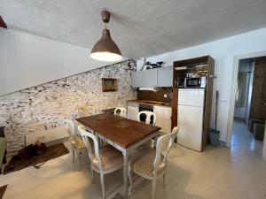 a kitchen with a wooden table and chairs at Apartamento Tana by SIERRA VIVA in Puerto-Gil +3 photos