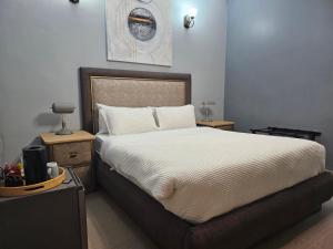 a bedroom with a large bed and two night stands at TACOA Boutique Hotel in Westonaria