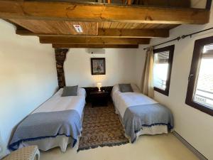 two beds in a room with two windows at Apartamento Tana by SIERRA VIVA in Puerto-Gil