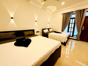 a hotel room with two beds and a couch at Surf del mar in Arugam Bay +34 photos