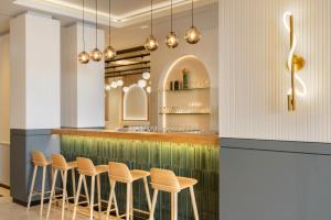 a row of stools at a bar in a restaurant at Barceló Dresden Newa in Dresden
