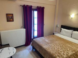a bedroom with a bed and a window with purple curtains at Hotel Siatistino Archontariki in Siátista +7 photos