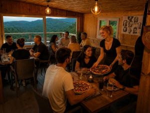 a group of people sitting at a table with pizza at Casa Versini in Balogna