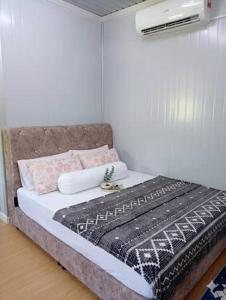 a bedroom with a bed with a blanket on it at D'Cabin Roomstay in Sungkai