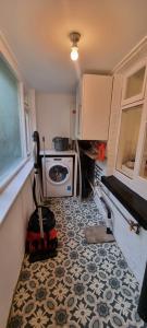 a small kitchen with a mop and a stove at Sage Cottage Ventnor in Ventnor