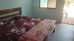 a bedroom with a bed with a red comforter at Sanvi Resort Malvan in Malvan