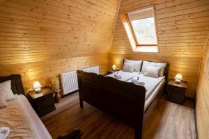 a bedroom with a large bed in a wooden room at Székelyföld,Siklódi Kő Vendégház Szénatároló in Şiclod