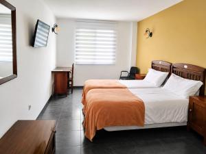a hotel room with a bed with an orange blanket at Casa Rural Casole in Castalla