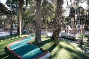 a pool in a park with trees and grass at Ocean Ridge Resort 1BR Apartment in Edisto Island