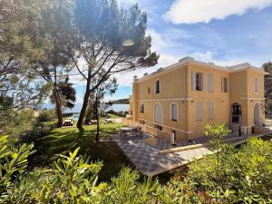 a large yellow house with trees and bushes at Caravelle 60 in Antibes