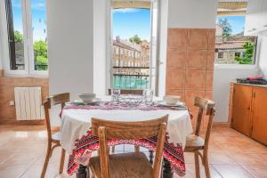 a dining room with a table and chairs and windows at Boni in Saint-Julien-Molin-Molette