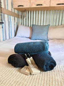 a bed with a pile of towels on it at Romantic Hot Tub Retreat - Ndlovu 33 Tiny Home, Big 5 reserve in Klipdrift