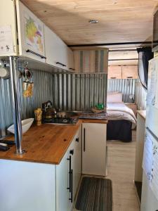 a kitchen with a sink and a bed in a room at Romantic Hot Tub Retreat - Ndlovu 33 Tiny Home, Big 5 reserve in Klipdrift +35 photos